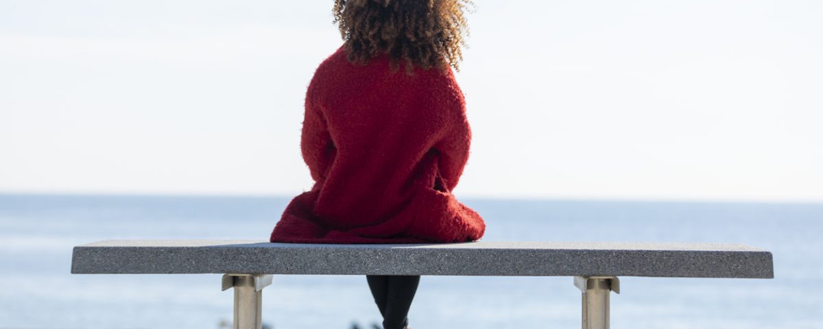 Woman looking out to see, thinking about mind-gut connection, in red