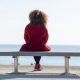 Woman looking out to see, thinking about mind-gut connection, in red