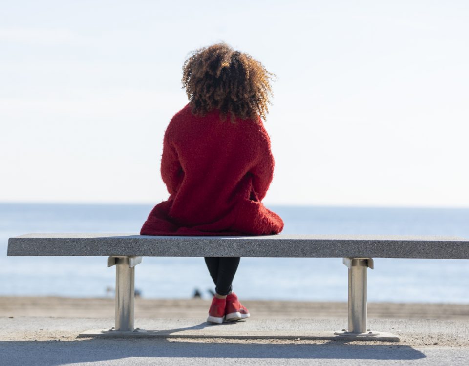 Woman looking out to see, thinking about mind-gut connection, in red